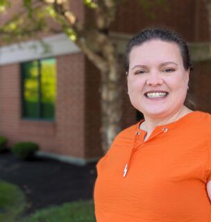 Dr. Kali Hollingsworth, Sports Medicine Fellowship Director, smiling for a photo outside a building